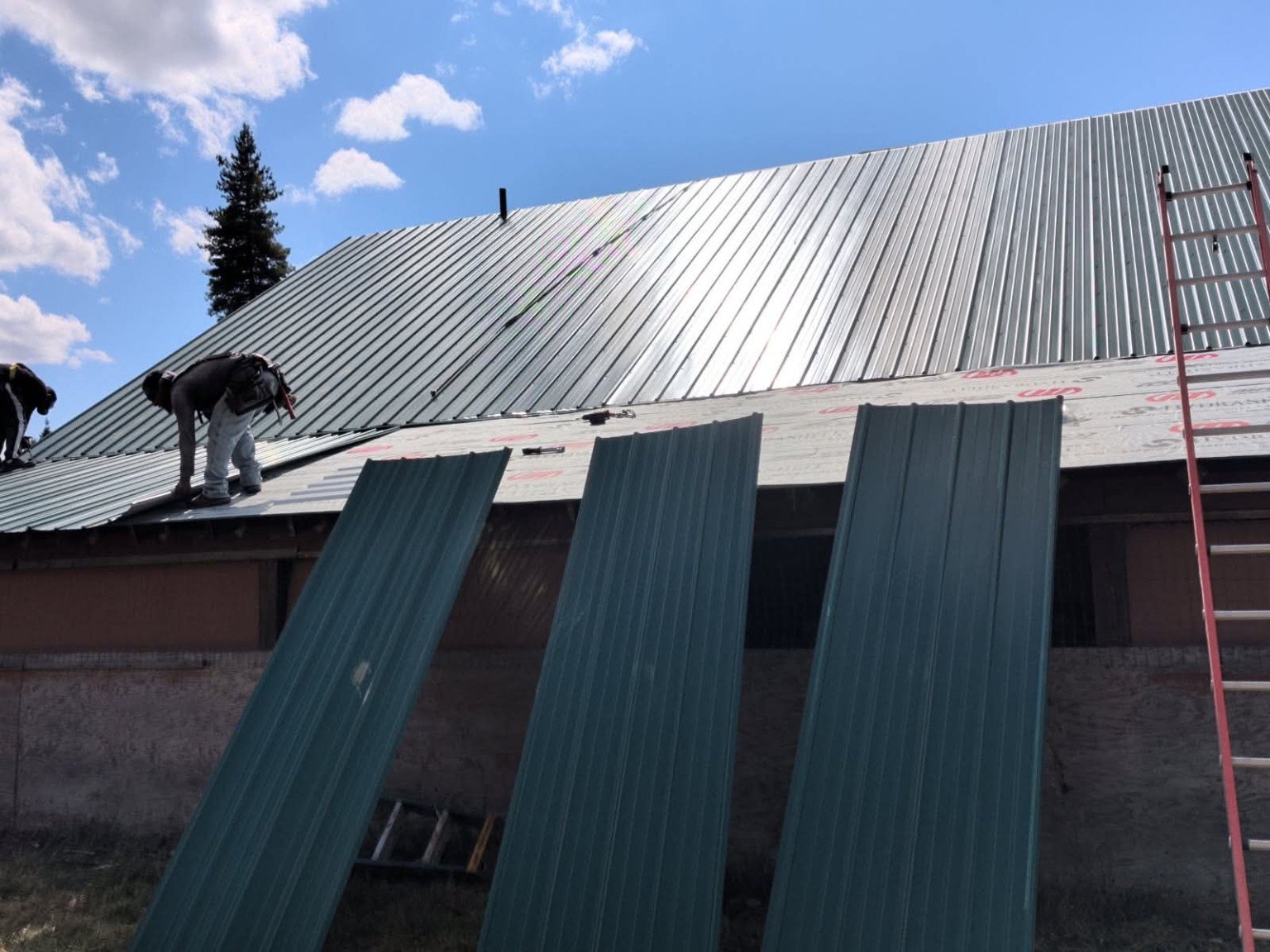 Iron Cross Builders crew installing metal roofing